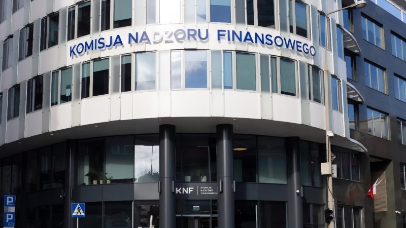 Budynek Komisji Nadzoru Finansowego (KNF) w Warszawie, widok na główne wejście z charakterystycznym logo instytucji.