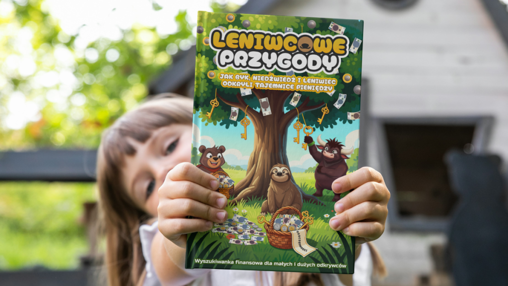 Okładka książki „Leniwcowe Przygody” Rafała Łapacia trzymana przez dziecko